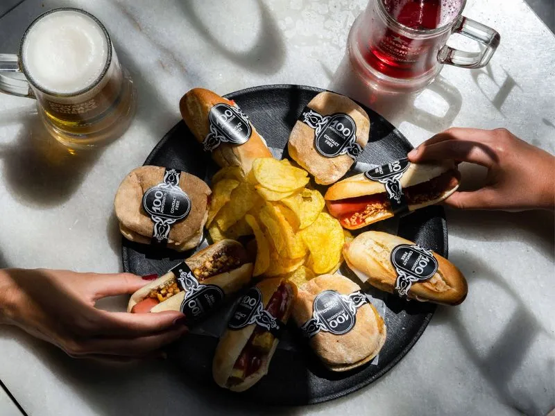 Mesa de bar con bocatas, jarra de cerveza y tinto de verano.