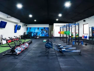 Sala interior de gimnasio con máquinas de cardio y fuerza